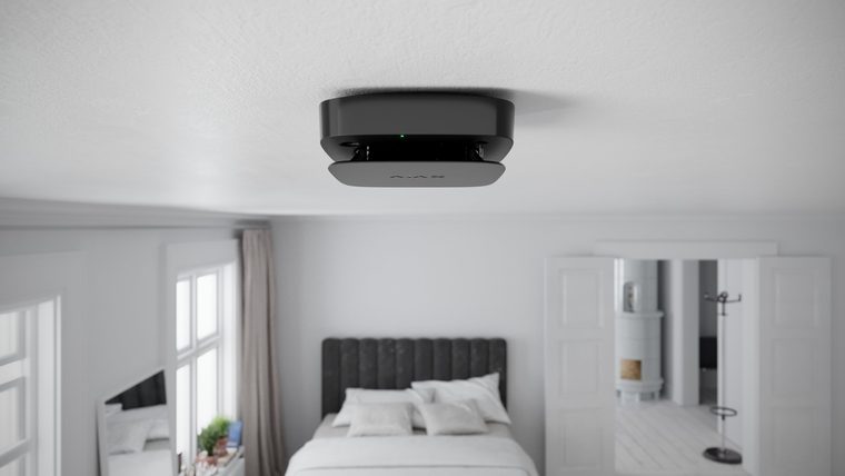 Ajax FireProtect 2 smoke detector on a bedroom ceiling